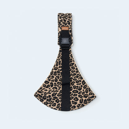 Portabebé bandolera leopardo, abierto sobre fondo celeste