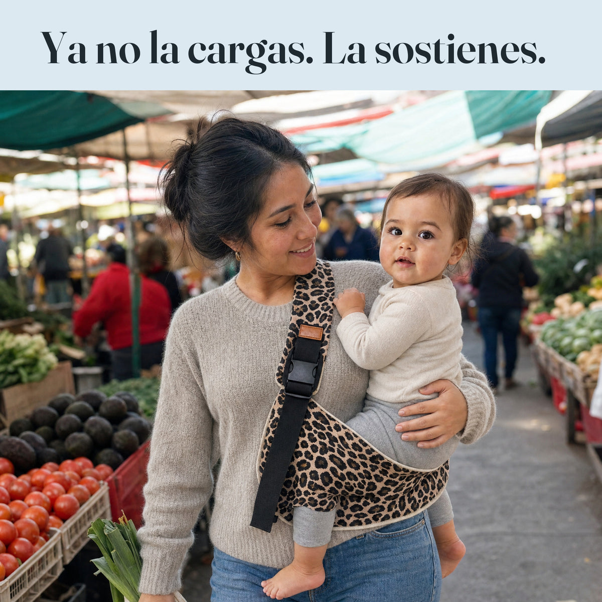 Mamá en la feria con la guagua sentada en su cadera en la bandolera